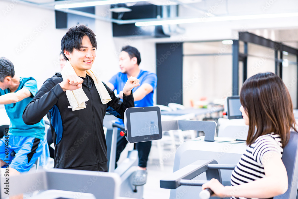 ジムでトレーナーの指導を受ける若い女性