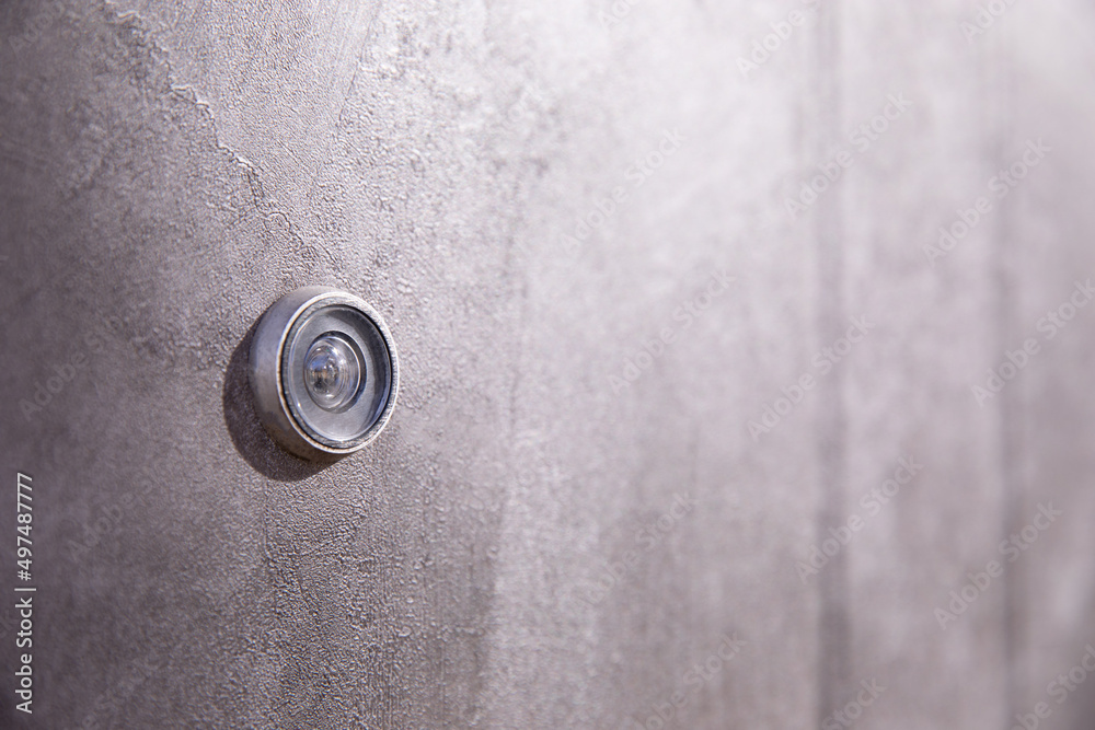 Door peephole on a dark gray metal door. Side view. copy space. Door peephole on a dark gray metal door. Side view. copy space.