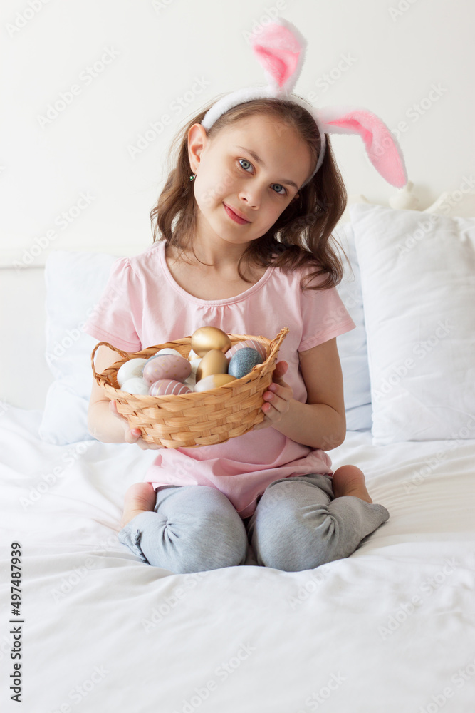 A little girl holds a basket of Easter eggs in her hands A little girl holds a basket of Easter eggs in her hands