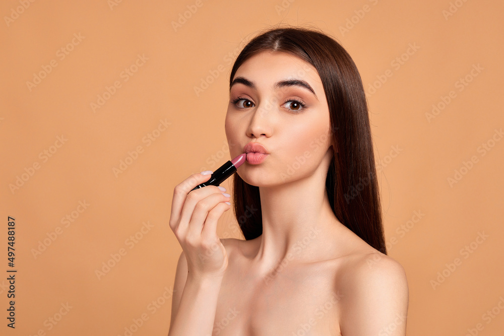 young happy positive woman holding pink lipstick young happy positive woman holding pink lipstick
