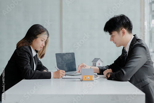 Rental company employee is discussing the details before the customer agrees to sign a rental contract, explaining the details and the terms and conditions of the rental. Real estate rental ideas.