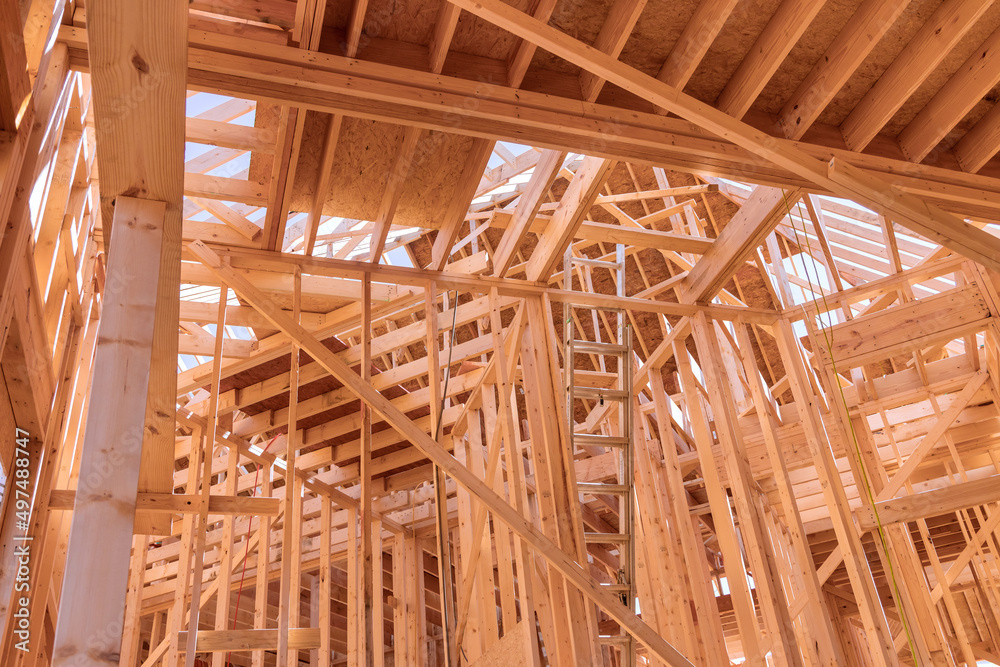 Wooden framing the wall of planks new residential house with construction site Wooden framing the wall of planks new residential house with construction site