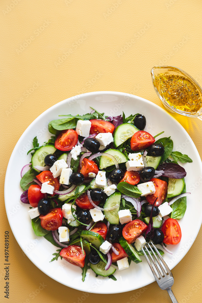 Greek salad of fresh cucumber, tomato, red onion, feta cheese and olives with olive oil. Healthy food, top view