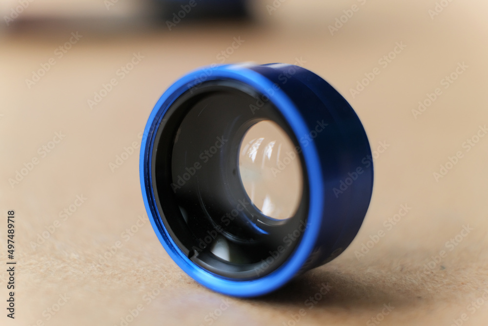 Fotografie Macro External additional lens for smartphone on wooden table.
