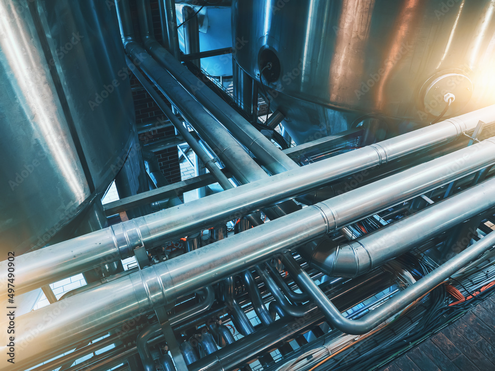 Large steel tanks and pipes. Industrial brewery factory pipelines in abstract blue color. Industry background. Large steel tanks and pipes. Industrial brewery factory pipelines in abstract blue color. Industry background.