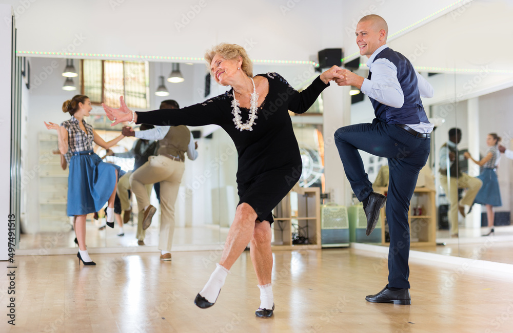 Mature woman dancing swing with young man