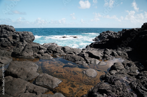 Lava rock shoreline with aqua blue waves and water