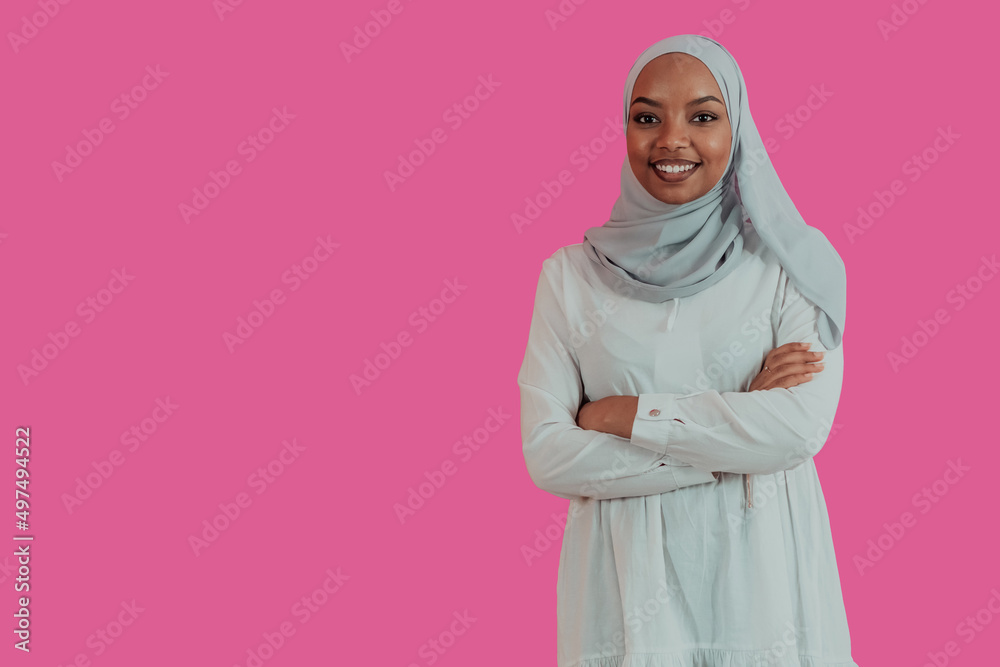 Portrait of young modern muslim afro beauty wearing traditional islamic clothes on plastic pink background. Selective focus Portrait of young modern muslim afro beauty wearing traditional islamic clothes on plastic pink background. Selective focus