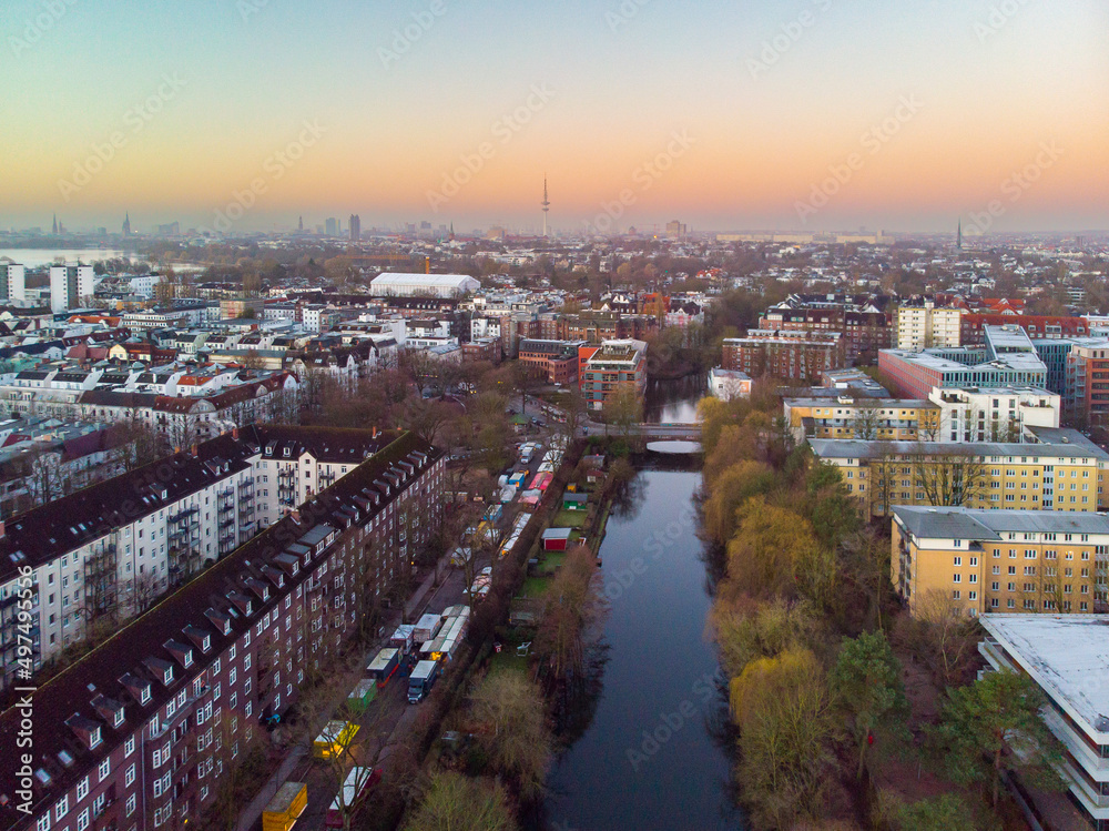 Drone aerial view of Hamburg during sunrise.
The skyline of Hamburg over the buildings and canals can be seen on a sunrise time.