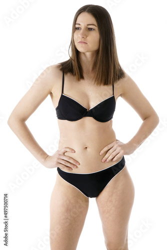 Slim athletic girl posing in black bikini in studio
