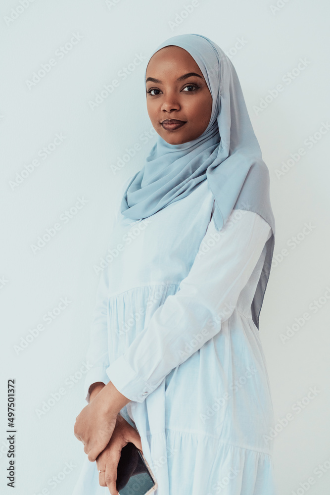An African Muslim woman using a smartphone on a white background An African Muslim woman using a smartphone on a white background