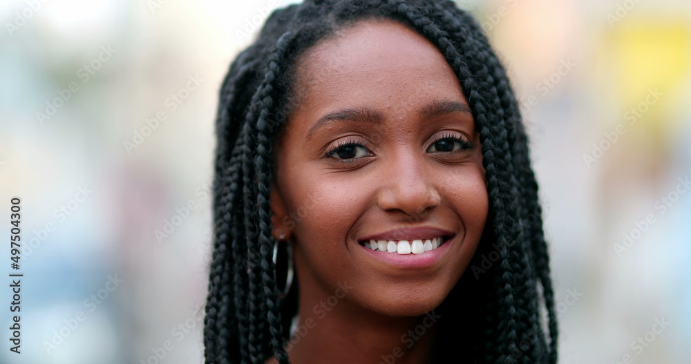 Portrait black African teen girl smiling at camera. Young woman face close-up