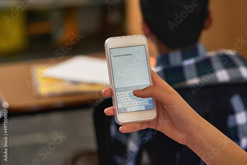 Not exactly captivated by the lesson plan. Shot of an unidentifiable schoolgirl using her smartphone in class.