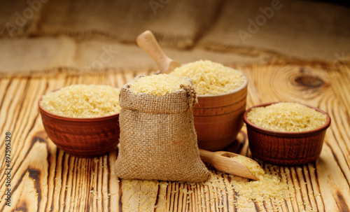 Polished steamed rice in bowls and bags on a wooden background. High quality photo