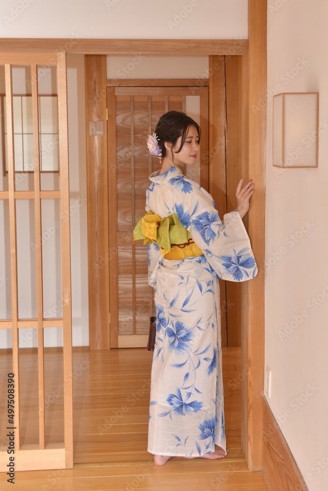 日本家屋の室内にたたずむ浴衣姿の若く美しい女性