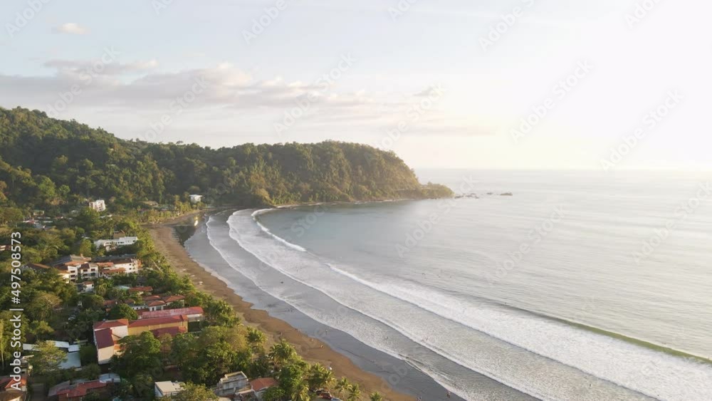 Beautiful, picturesque surf beach in Jaco, Costa Rica, during a stunning golden sunset. Wide angle aerial shot