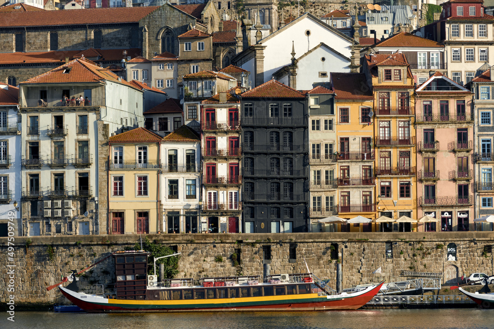 Colorful houses and traditional facades with red roof tiles on the embankment of Ribeira district in Porto, Portugal