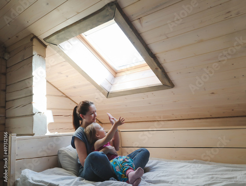 Portrait of enjoy happy family mother and little girl hugging, smiling, playing and having good time in a cozy room at home.
