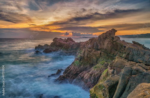 sunset view on the beach with rock cliffs 