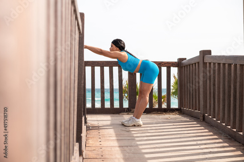 A pretty African American woman doing sports by the beach on a sunny day