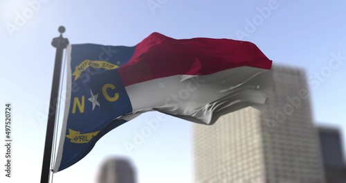 North Carolina state waving flag on blurry background, USA state news illustration. Blurry background