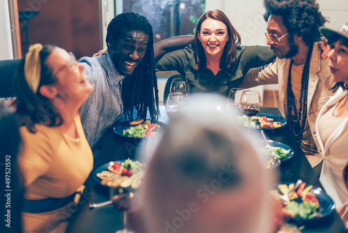 group of positive people sitting around the dinner table hugging each other celebrating - friends, family, team, colleagues, togetherness concept