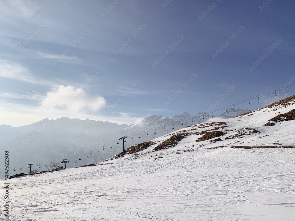 Winter landscape with mountain slopes covered with snow. Ski resort in the Italian Alps. Winter holidays destination. Winter landscape with mountain slopes covered with snow. Ski resort in the Italian Alps. Winter holidays destination.