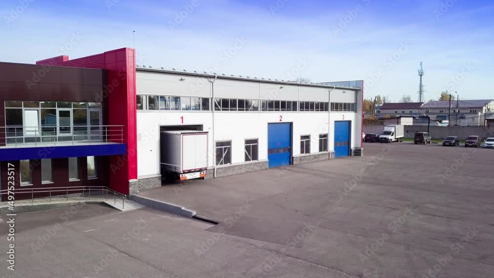Aerial view Red truck with a trailer drives out from a lorry truck service station after annual maintenance. Aerial view Red truck with a trailer drives out from a lorry truck service station after annual maintenance.