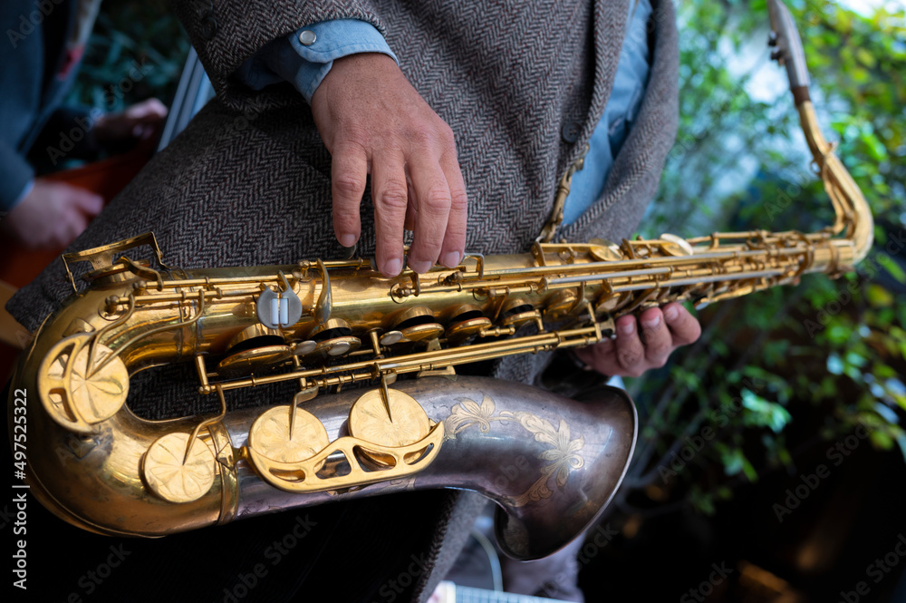Naklejka premium Close-up of a saxophone. Hands playing a saxophone. Musical instruments