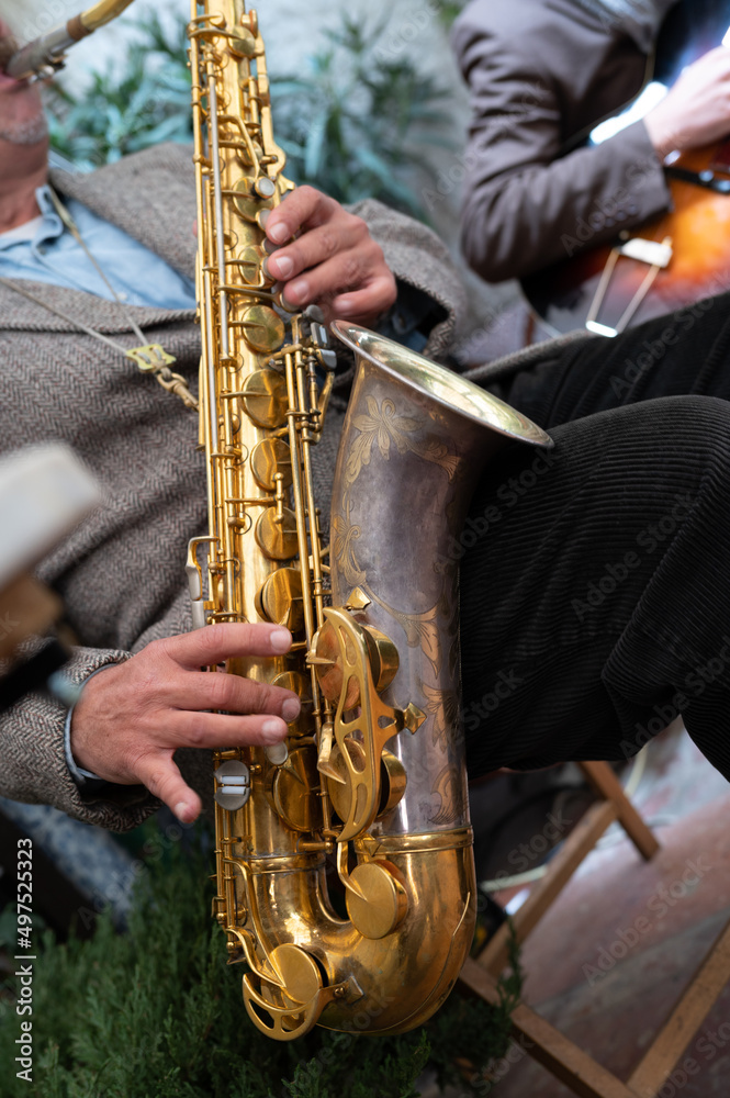 Naklejka premium Close-up of a saxophone. Hands playing a saxophone. Musical instruments