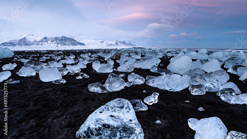Abendstimmung am Diamond Beach mit rosa Wolken über schwarzem Strand und Eisstücken, Breiðamerkursandur