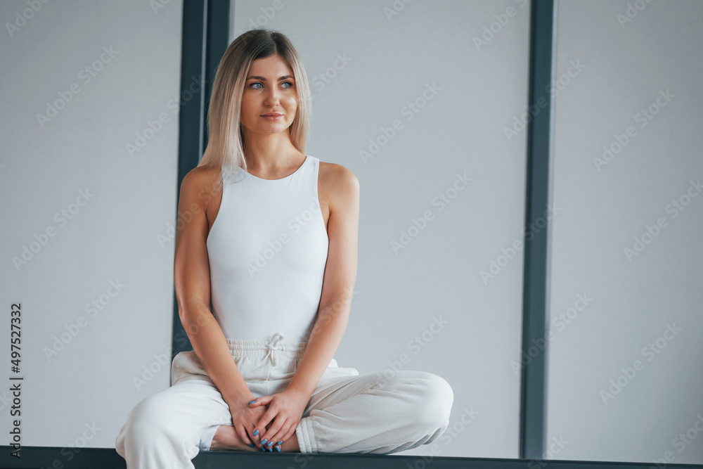 Woman in sportive clothes is standing in the studio Woman in sportive clothes is standing in the studio