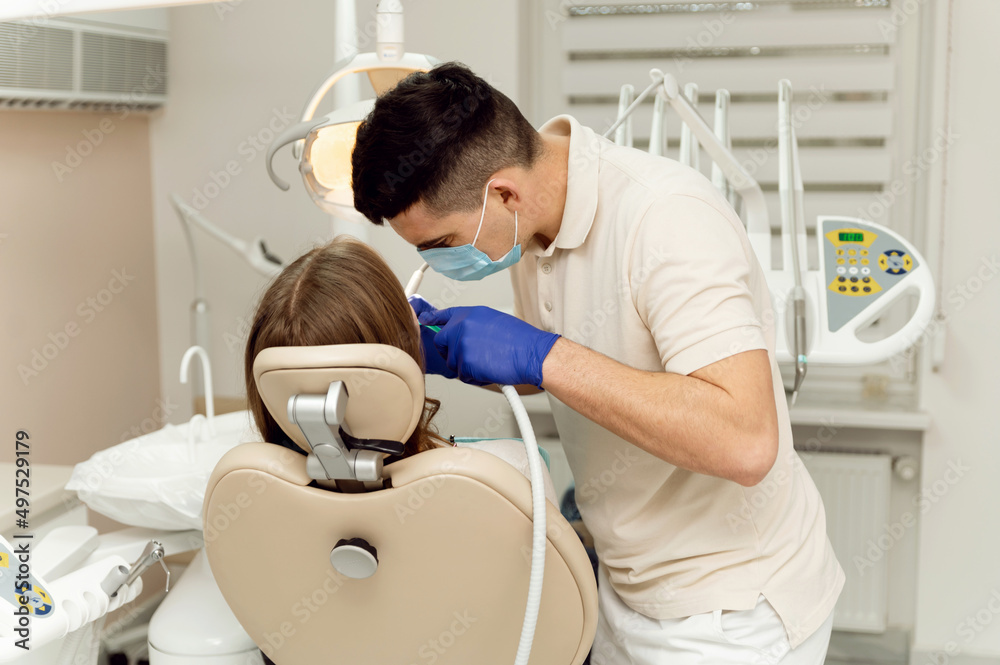 dental treatment process. the dentist holds the tools in his hands and examines the teeth. patient at the dentist. dental office. dental treatment process. the dentist holds the tools in his hands and examines the teeth. patient at the dentist. dental office.