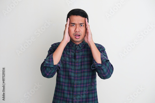 Adult Asian man cover both side of his face with hand photo