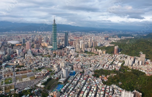 Aerial panorama over Downtown Taipei  capital city of Taiwan with view of prominent Taipei 101 Tower amid skyscrapers in Xinyi Financial District   overcrowded buildings in city center under sunny sky