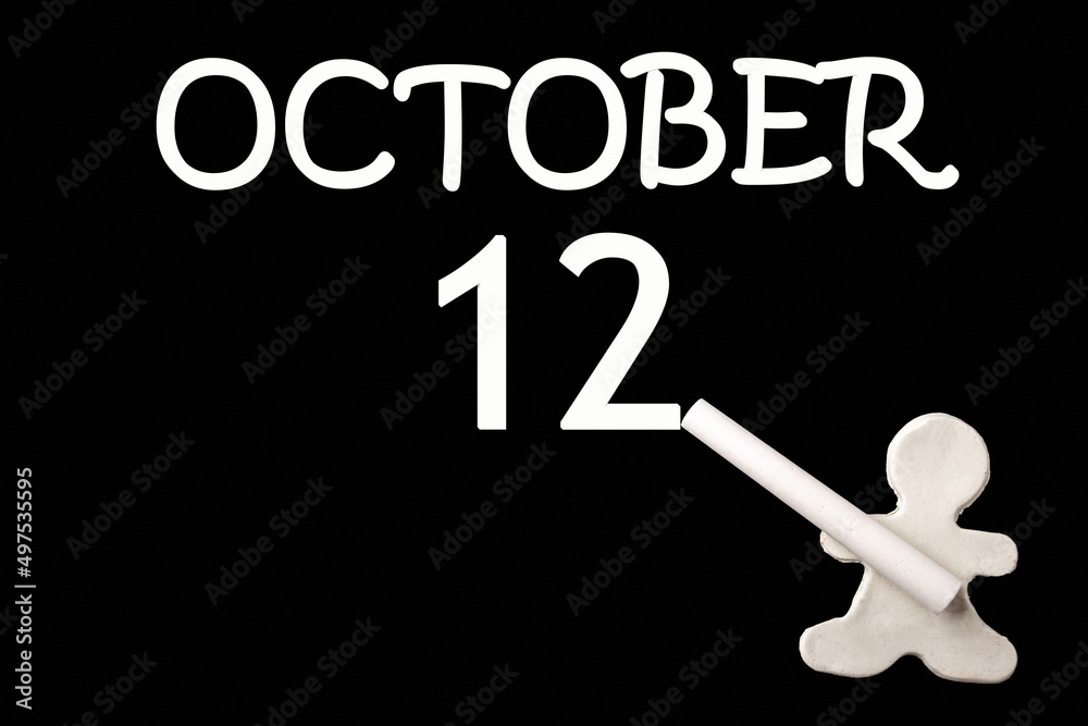 A small white plasticine man writing the date 12 October on a black board. Business concept. Education concept. A small white plasticine man writing the date 12 October on a black board. Business concept. Education concept.