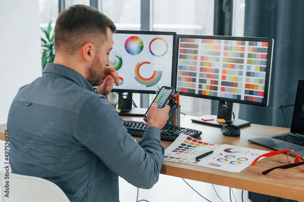 Using different colors. Male designer working in the office by using PC