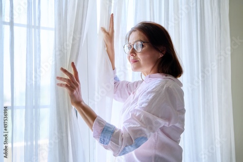 Smiling positive mature woman looking out the window © Valerii Honcharuk