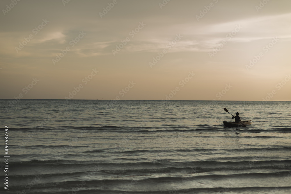 shot of kayak in calm blue sea on orange sunset background. Landscape Seascape, Amazing beach scene vacation and summer holiday concept. Luxury travel. background and copy space.