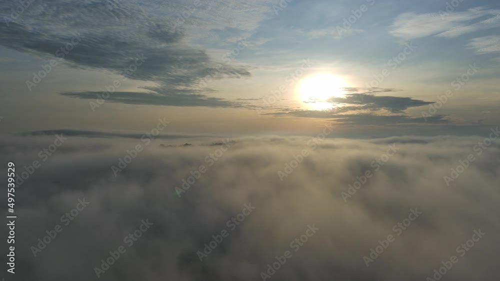 aerial view of camera taking pictures blur countryside under foggy in the morning and take higher over sea of mist