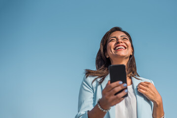 Portrait of a young Chinese girl happy with her cell phone. Copy space