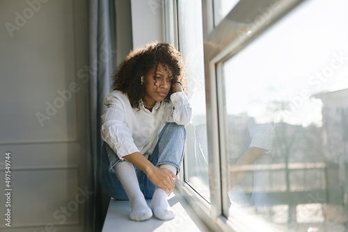 Depressed african American young woman sit at home feel desperate down suffering from relationships problems breakup, upset girl crying having life troubles         