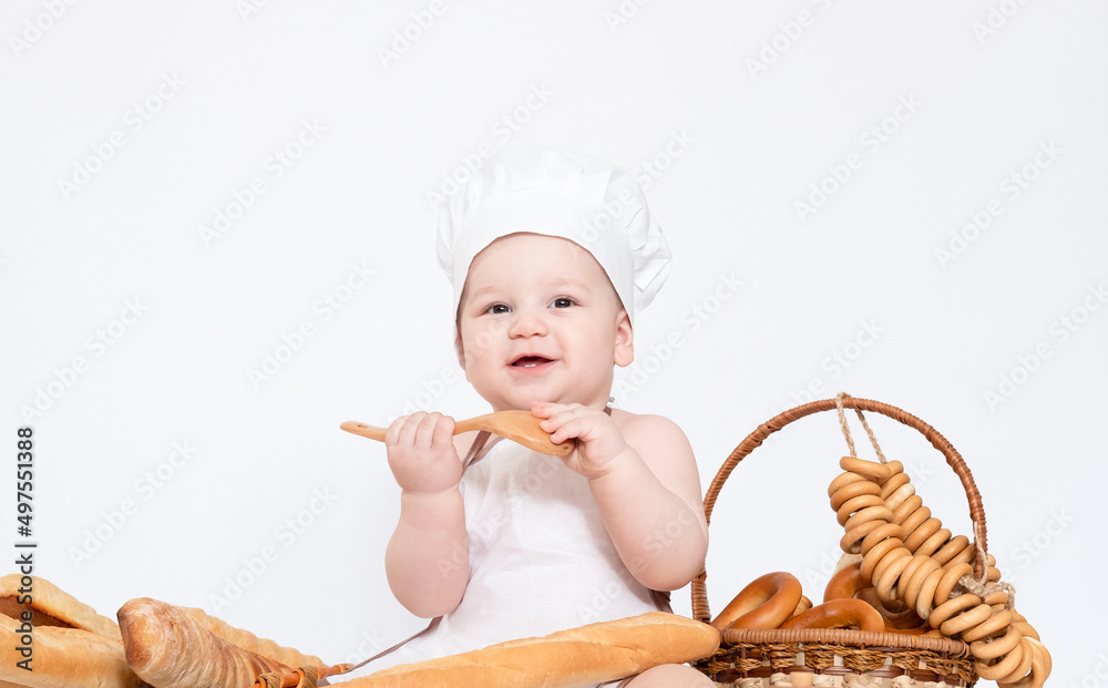 Little boy in a cook cap and with bread funny little chef Little boy in a cook cap and with bread funny little chef