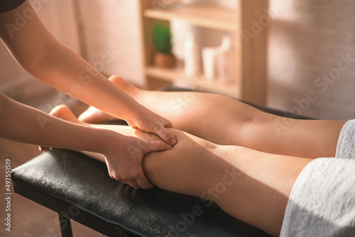 Close-up of a young woman undergoing reflexology. a masseur massages a young girl on her feet in a spa salon. the concept of body skin care