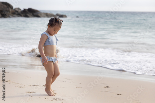 Cute Baby Girl in Bikini Walking on the Beach for Summer Vacation