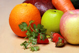 closeup of fresh fruit apple, orange, strawberry, grape; carrot; avocado isolated on wooden table