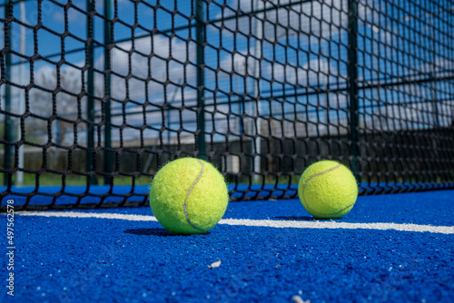 three balls near the net in a blue paddle tennis court © Vic