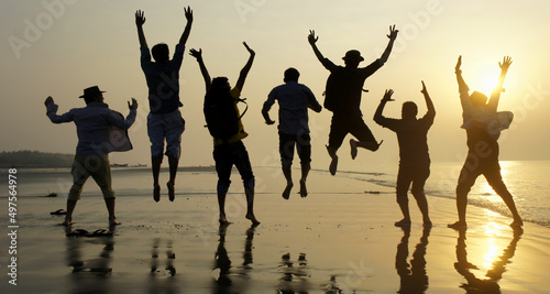 Big group of seven happy friends is having fun and jumping on beach during sunset time at Kuakata sea beach, Bangladesh photo