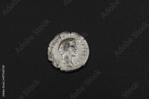 Silver ancient Roman coin on a black background