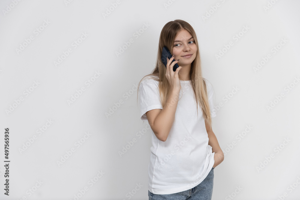 beautiful caucasian girl on a white background in casual clothes talking on the phone beautiful caucasian girl on a white background in casual clothes talking on the phone